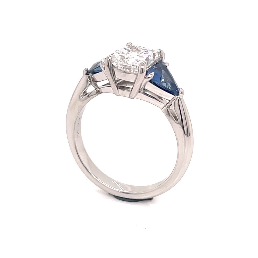 A white gold ring with a diamond and sapphire on a white background.