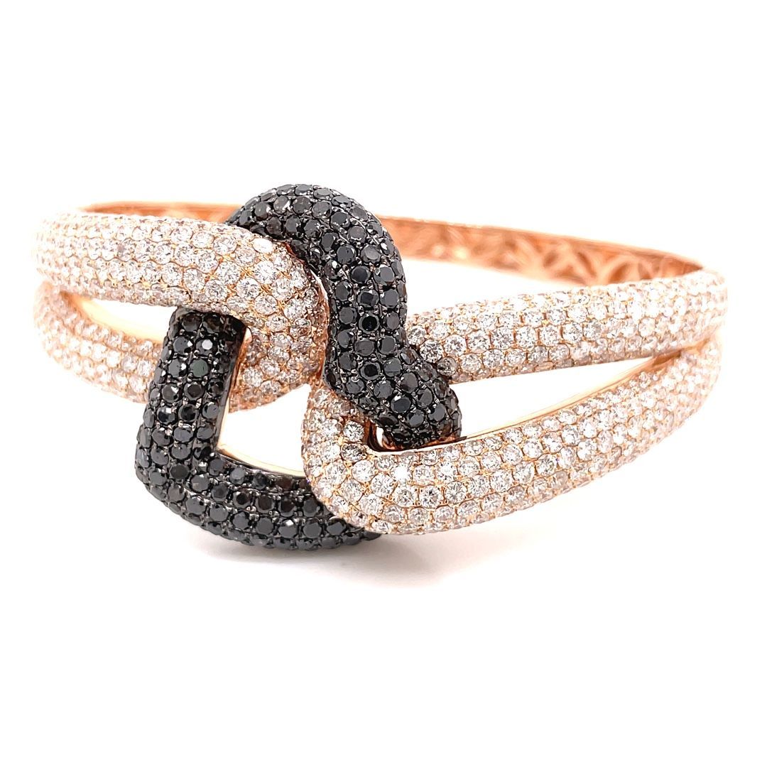 A close up of a bracelet with black and white diamonds on a white background.