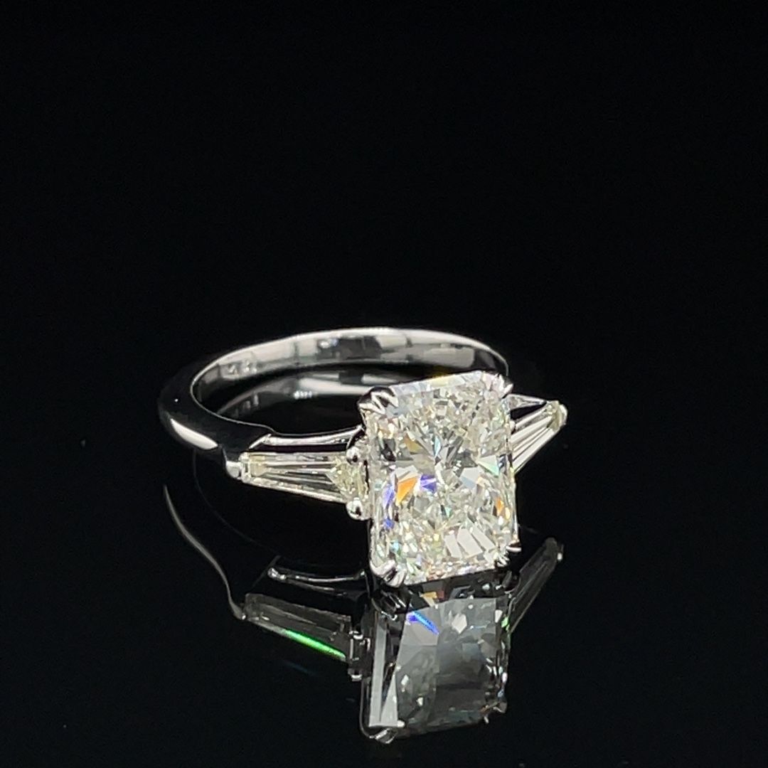 A diamond ring is sitting on a black surface.