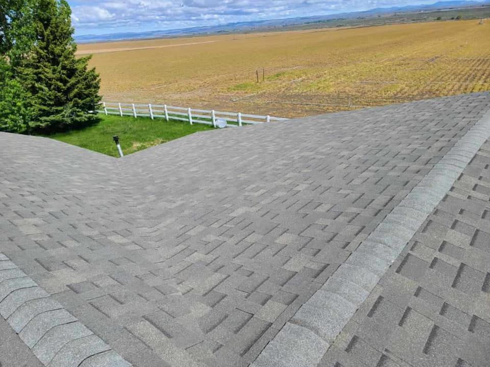 A roof with a view of a field and a fence.