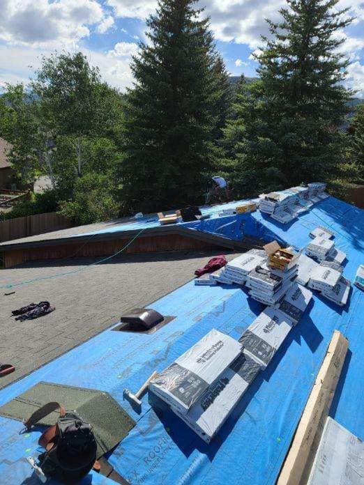 A blue tarp is covering the roof of a house.