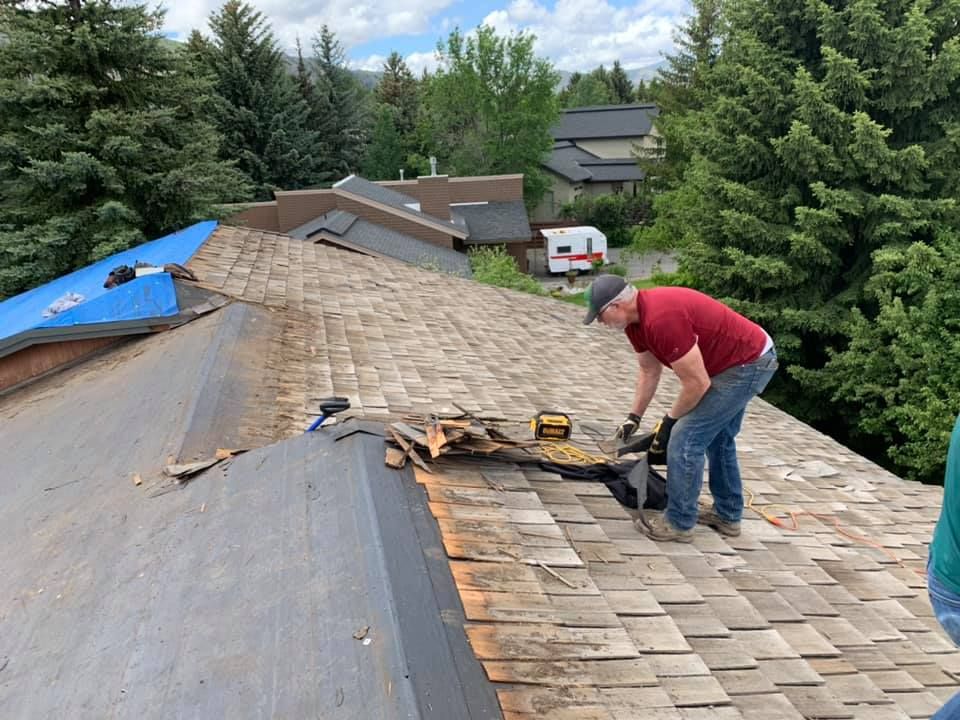 A man is working on the roof of a house.