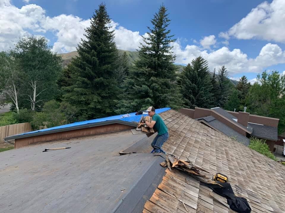 A man is working on the roof of a house.