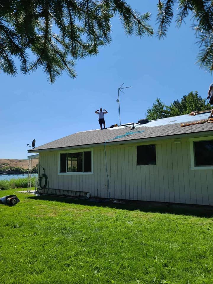 A man is standing on the roof of a house.
