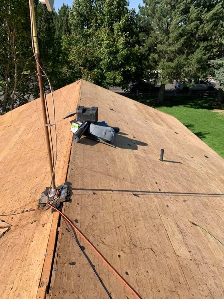 The roof of a house is being remodeled and is being covered in plywood.