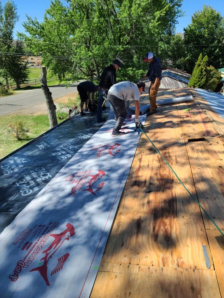 A group of men are working on a roof.