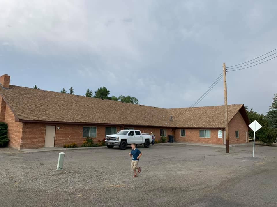 A white truck is parked in front of a brick building