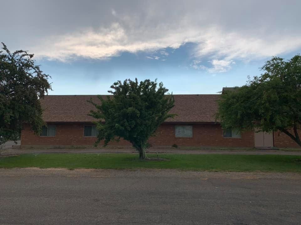 A brick house with a tree in front of it