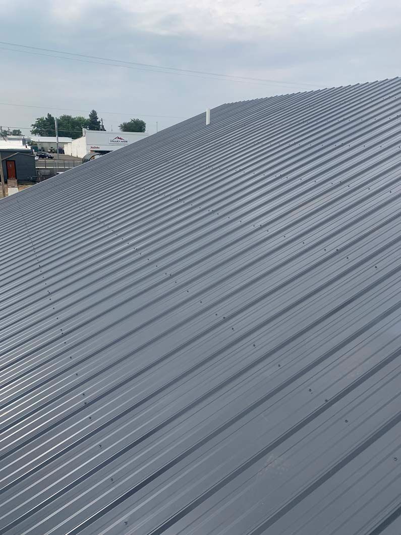 A close up of a metal roof with a blue sky in the background.