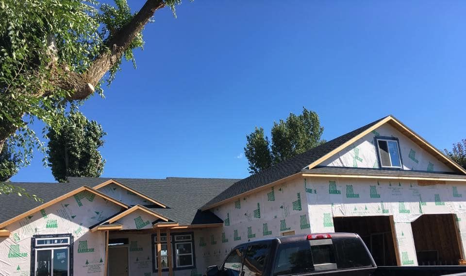 A truck is parked in front of a house under construction.