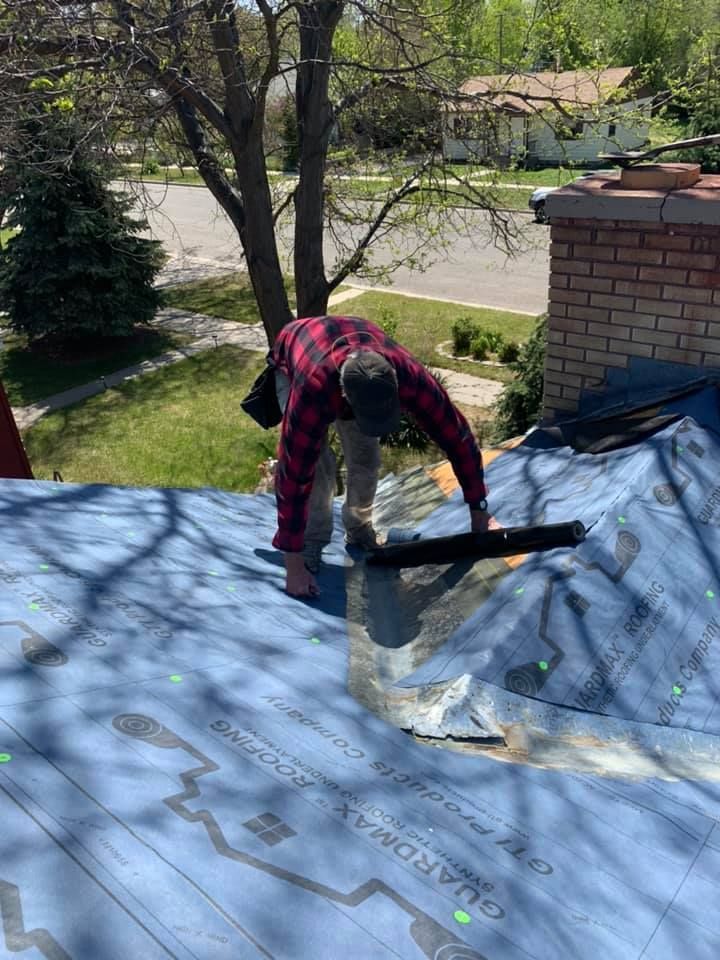 A man is working on the roof of a house.