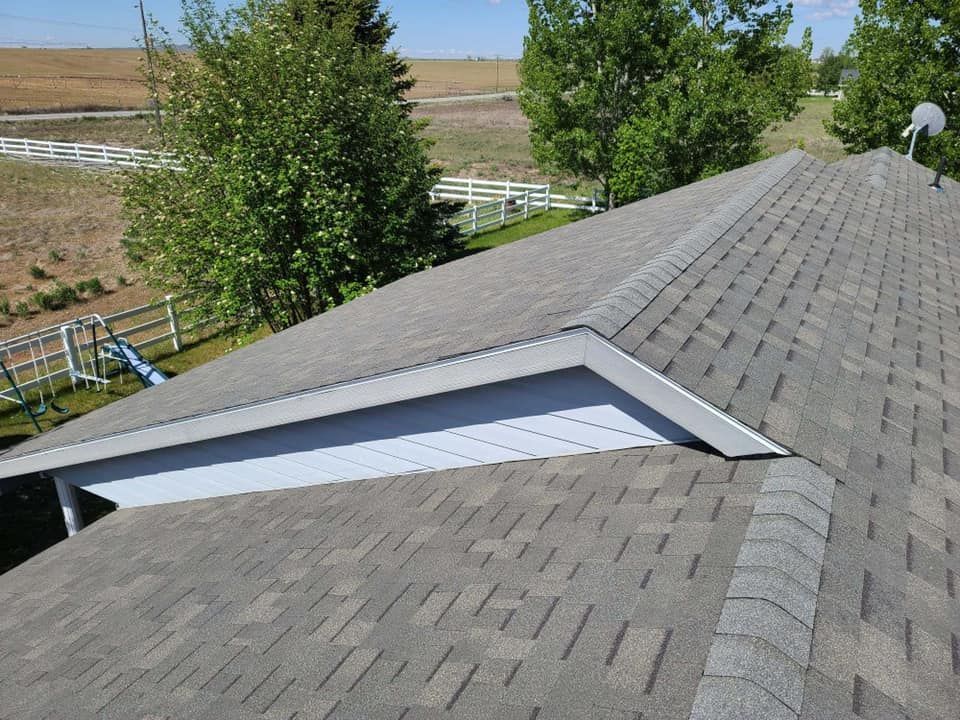 A roof with a white trim and a few trees in the background