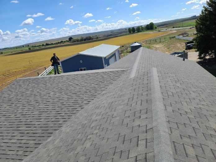 A man is standing on the roof of a house