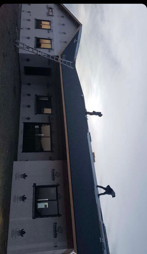 A man is working on the roof of a house.