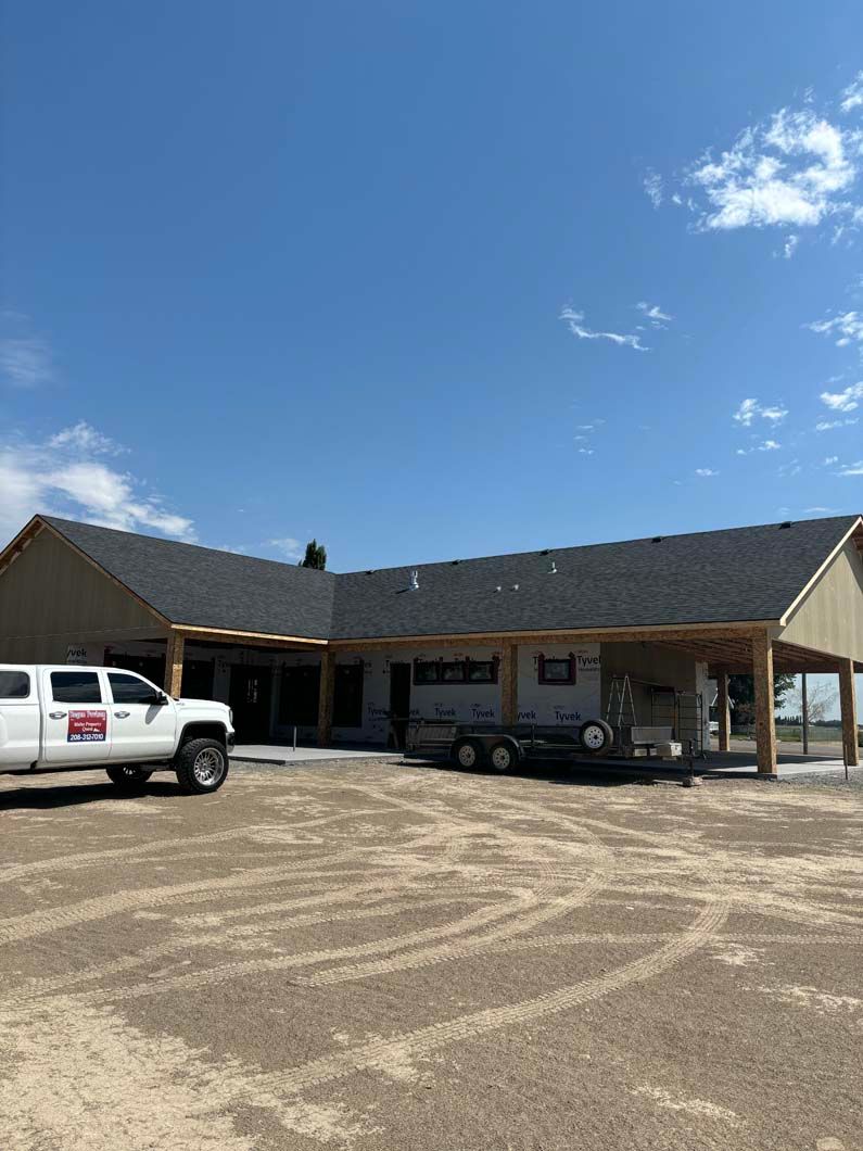 A white truck is parked in front of a large house.