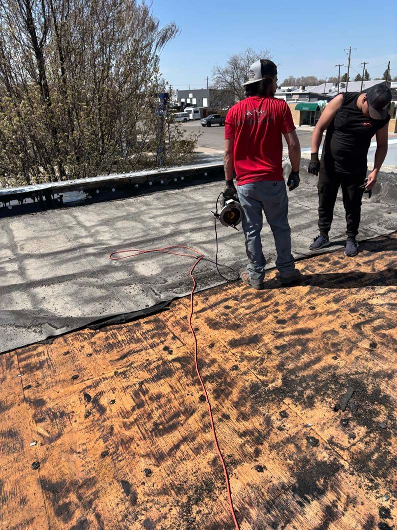 Two men are standing on top of a roof.