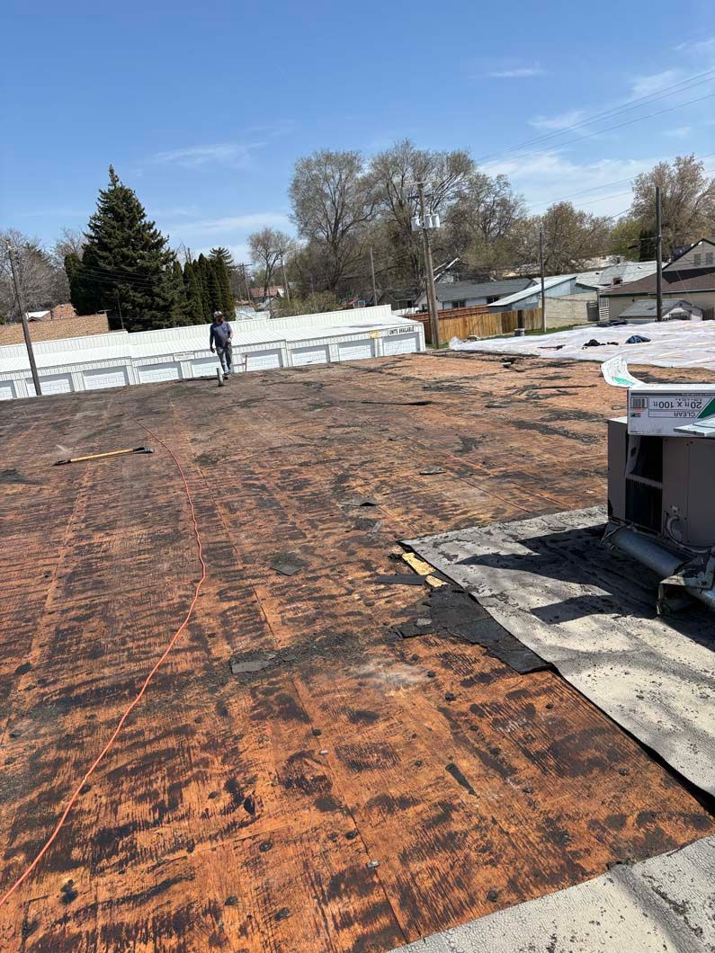 A man is standing on a roof that is being remodeled.