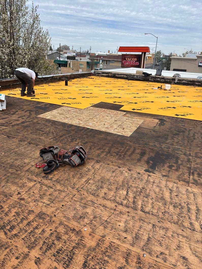 A man is working on the roof of a building.