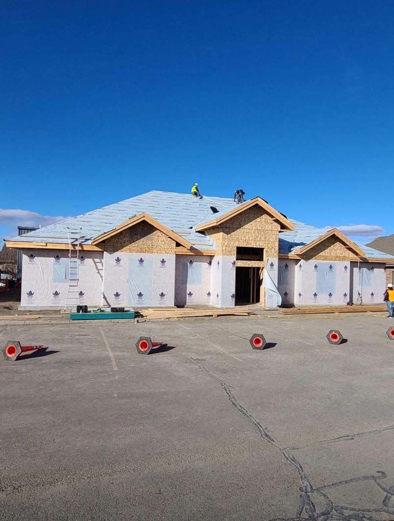 A house is being built with a roof that is being installed.