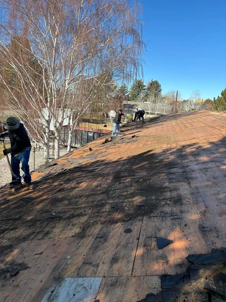 A group of people are working on the roof of a house.