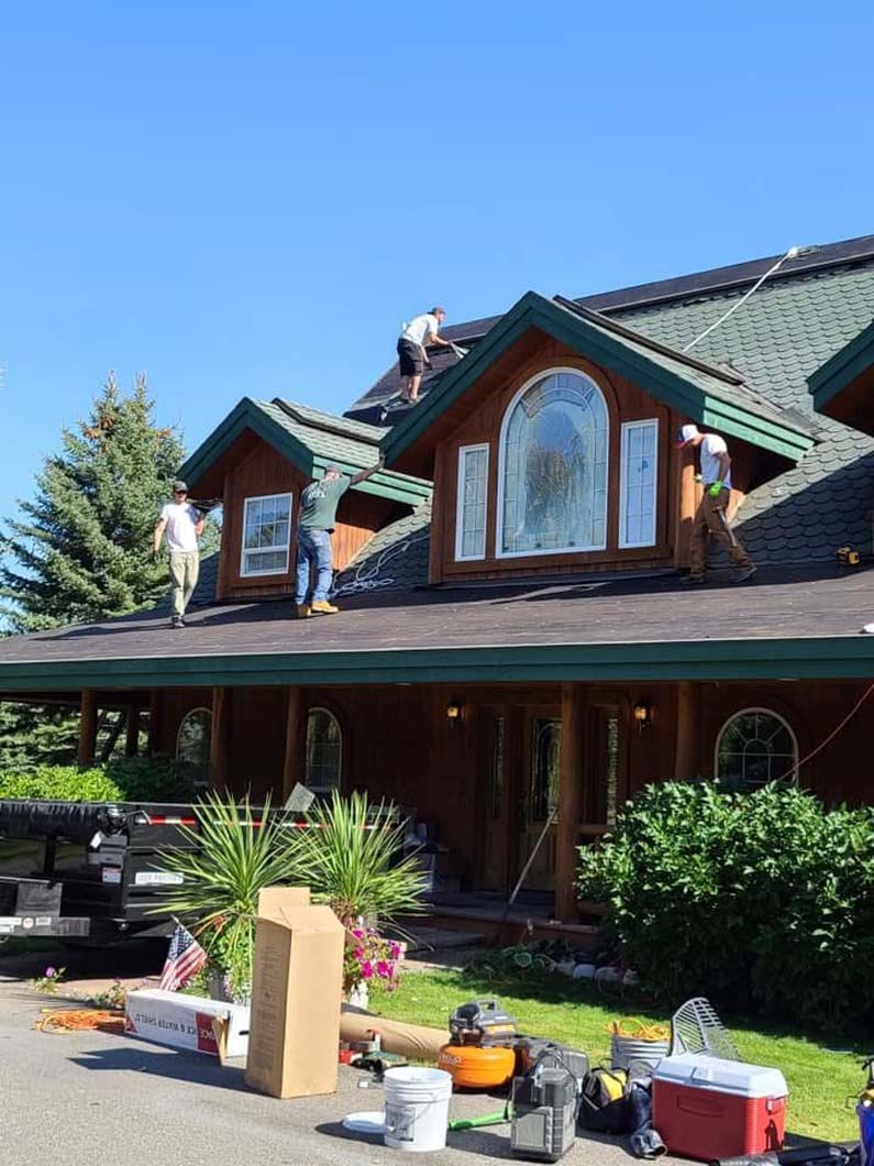 Two men are working on the roof of a house.