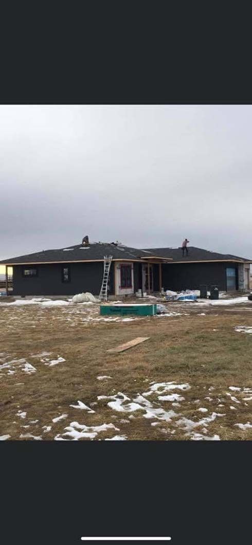 A large house is being built in the middle of a snowy field.