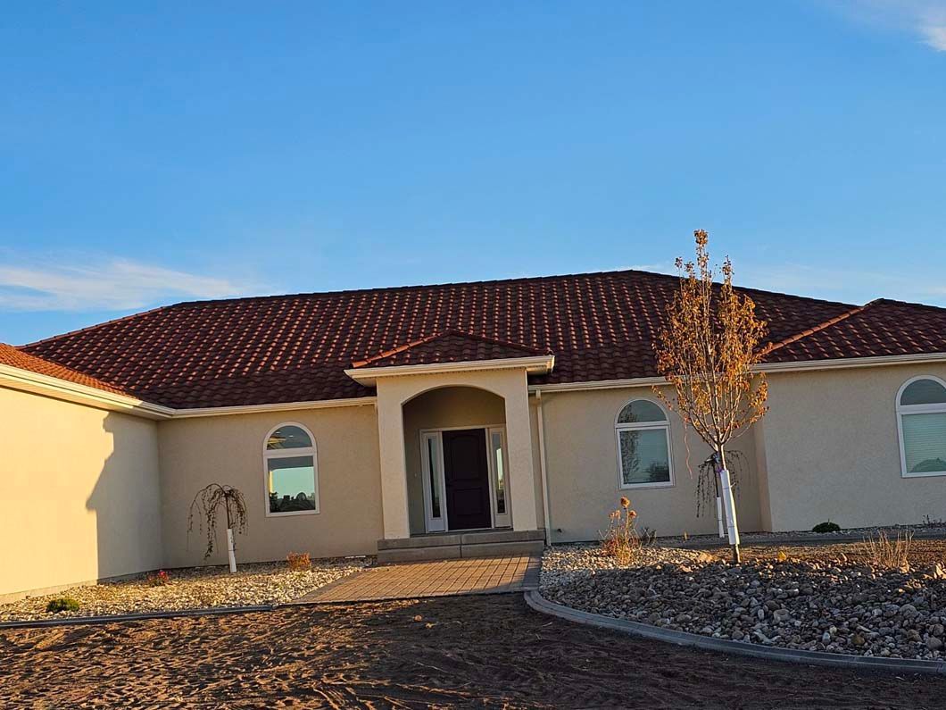 A house with a red tile roof and a tree in front of it