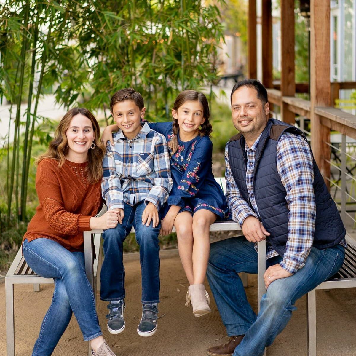 A family is posing for a picture while sitting on a bench in Costa Mesa.