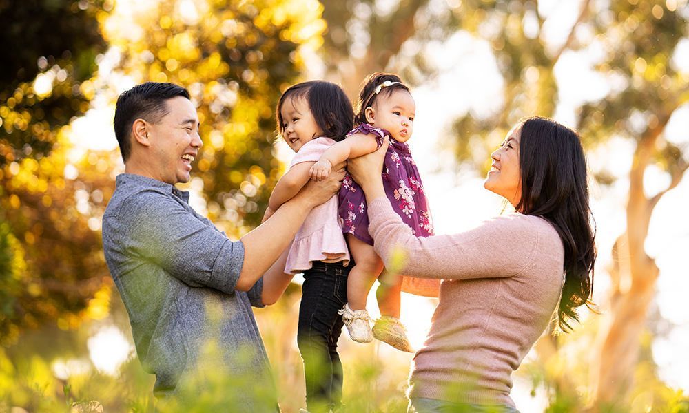 Huntington Beach Family Photo A family is posing for a picture in a park.
