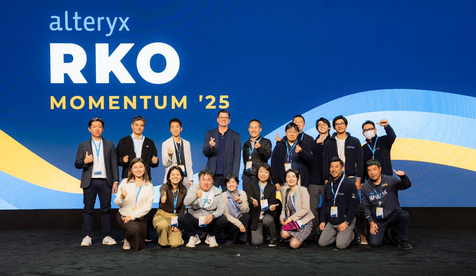 group photo at convention and conference alteryx A group of people standing on stage in front of an