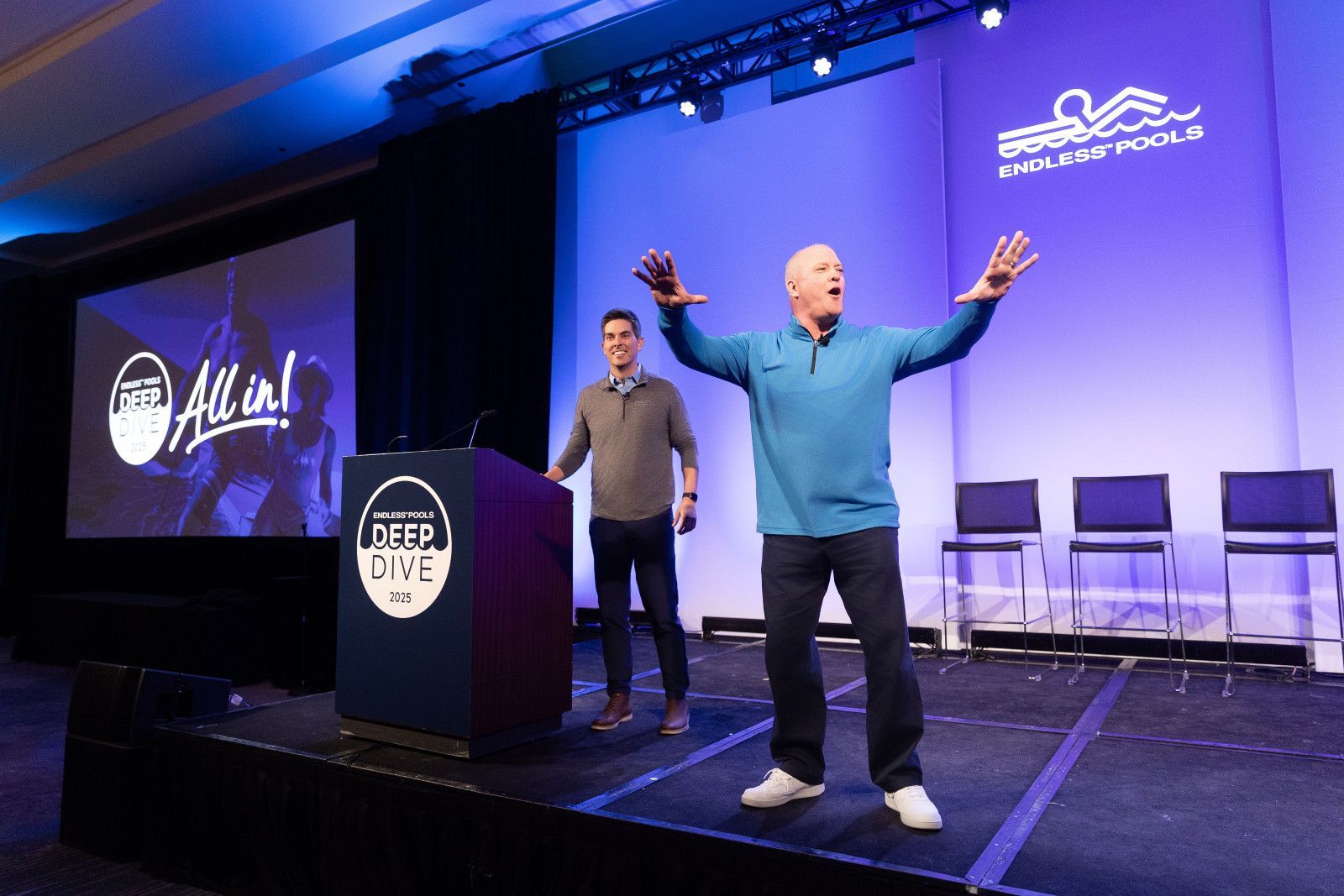 Corporate event Photographer Anaheim Two speakers on a stage at a conference; one stands behind a