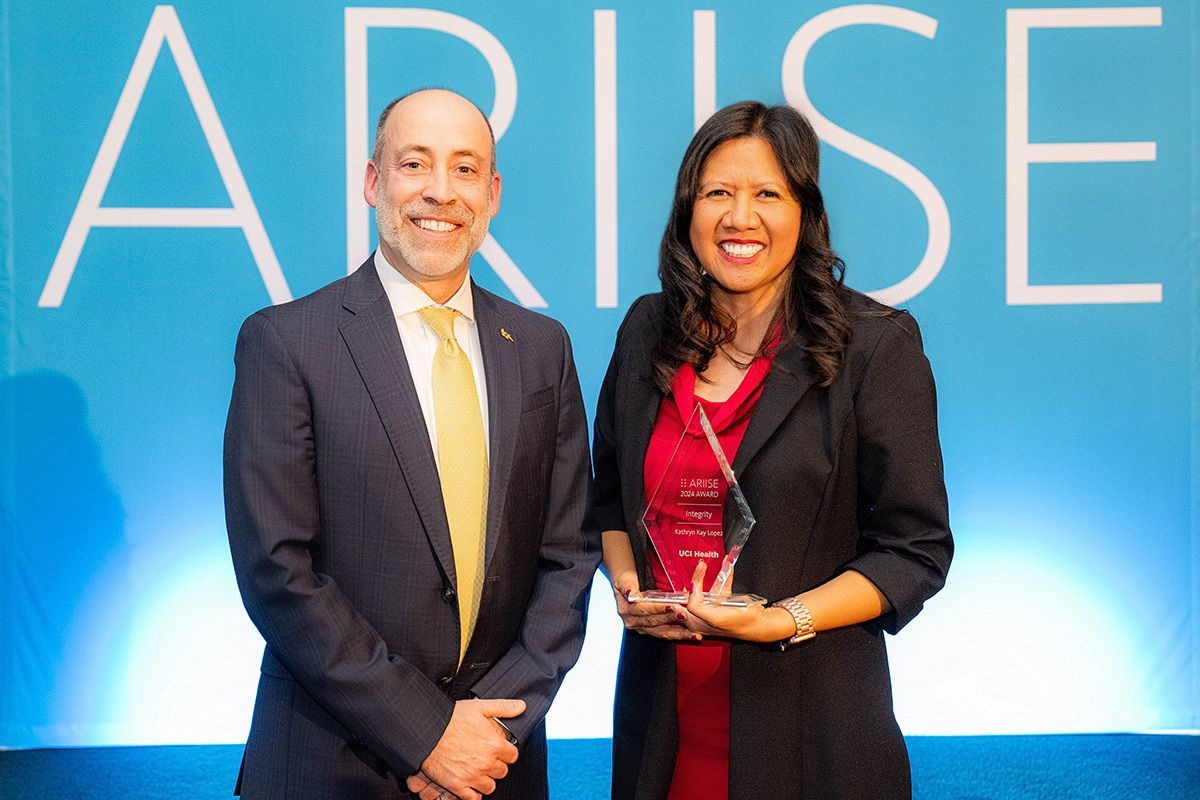 A man and a woman standing in front of a sign that says arise