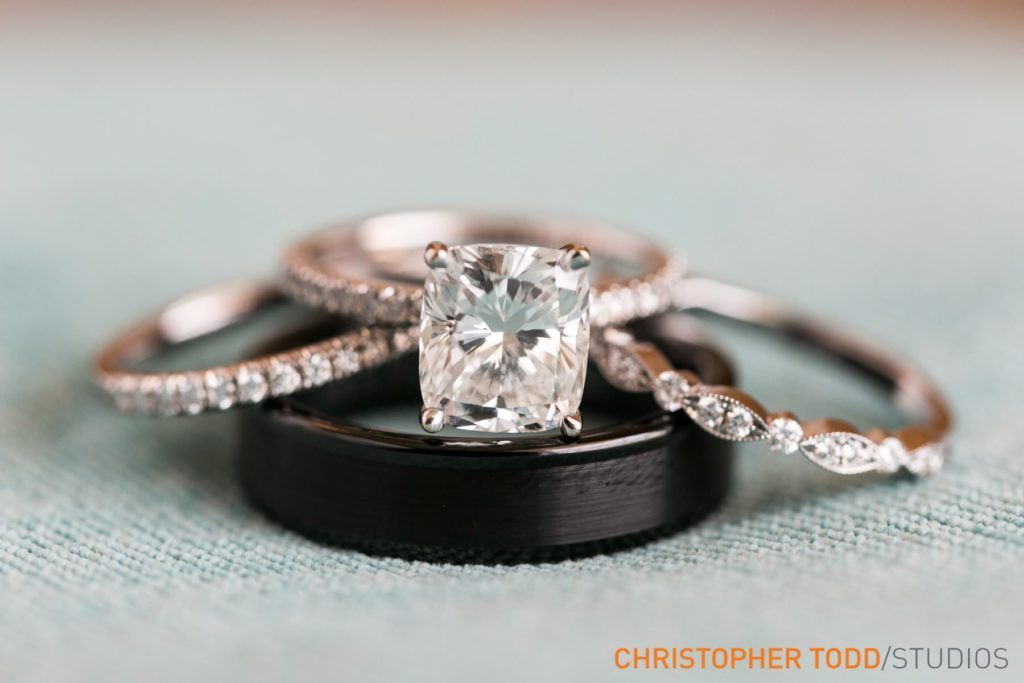 A bride and groom 's wedding rings are stacked on top of each other.