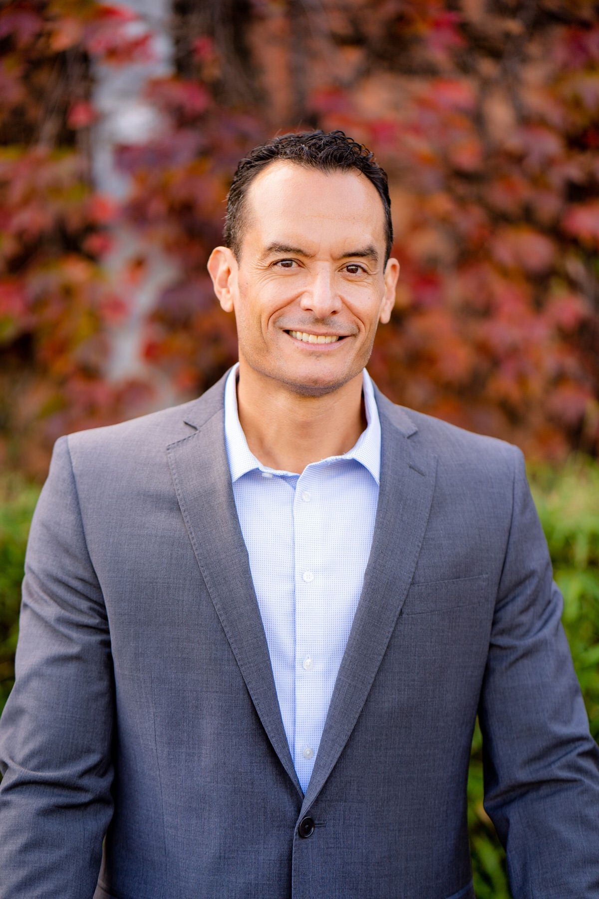 A man in a suit and blue shirt is smiling for the camera.