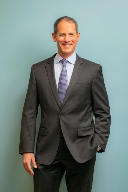 A man in a suit and tie is smiling for the camera.