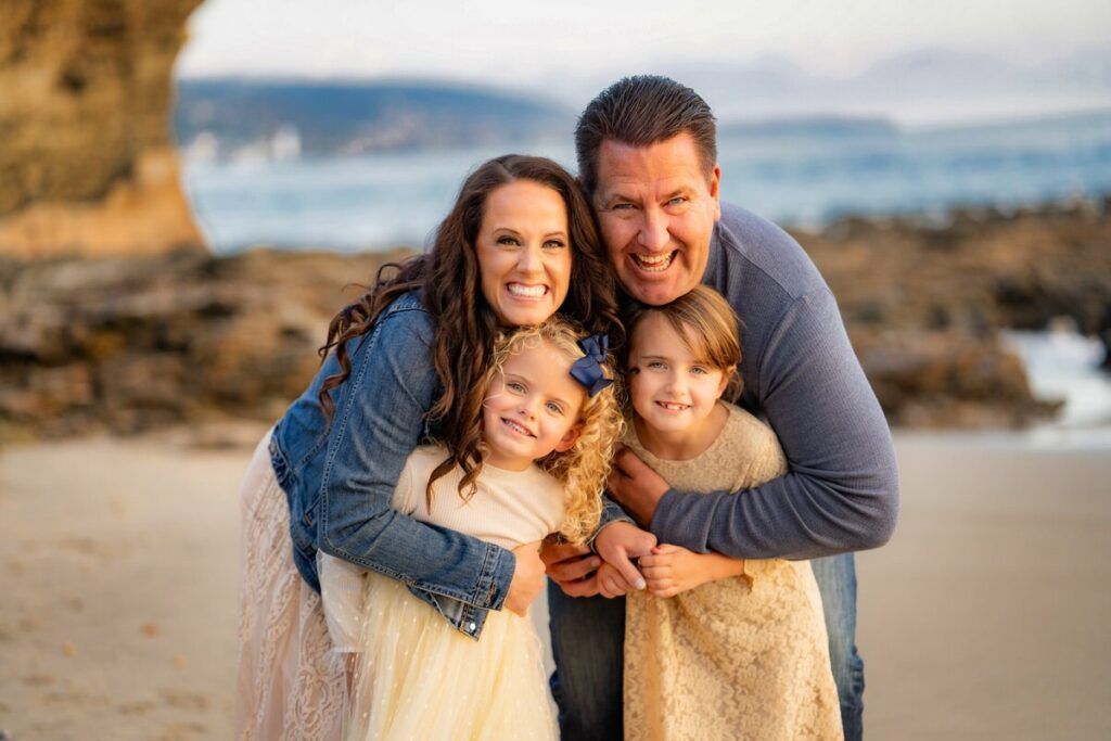 A family is posing for a picture on the beach.
