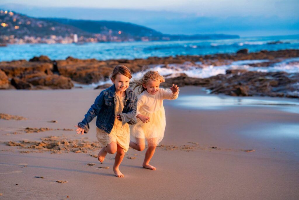 young sisters are running on the beach.