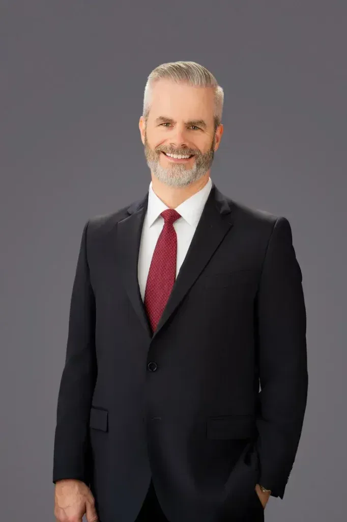Business Headshot Example A man in a suit and tie is standing with his hands in his pockets.