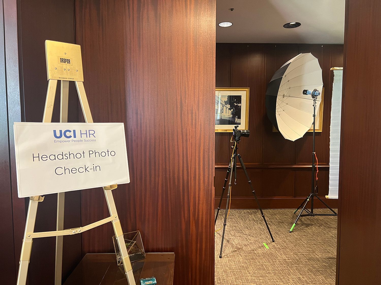Corporate Team Headshot Photo Day Irvine Handshot photo check-in sign on easel. Photo studio setup: camera on tripod, large light reflector, in hallway.