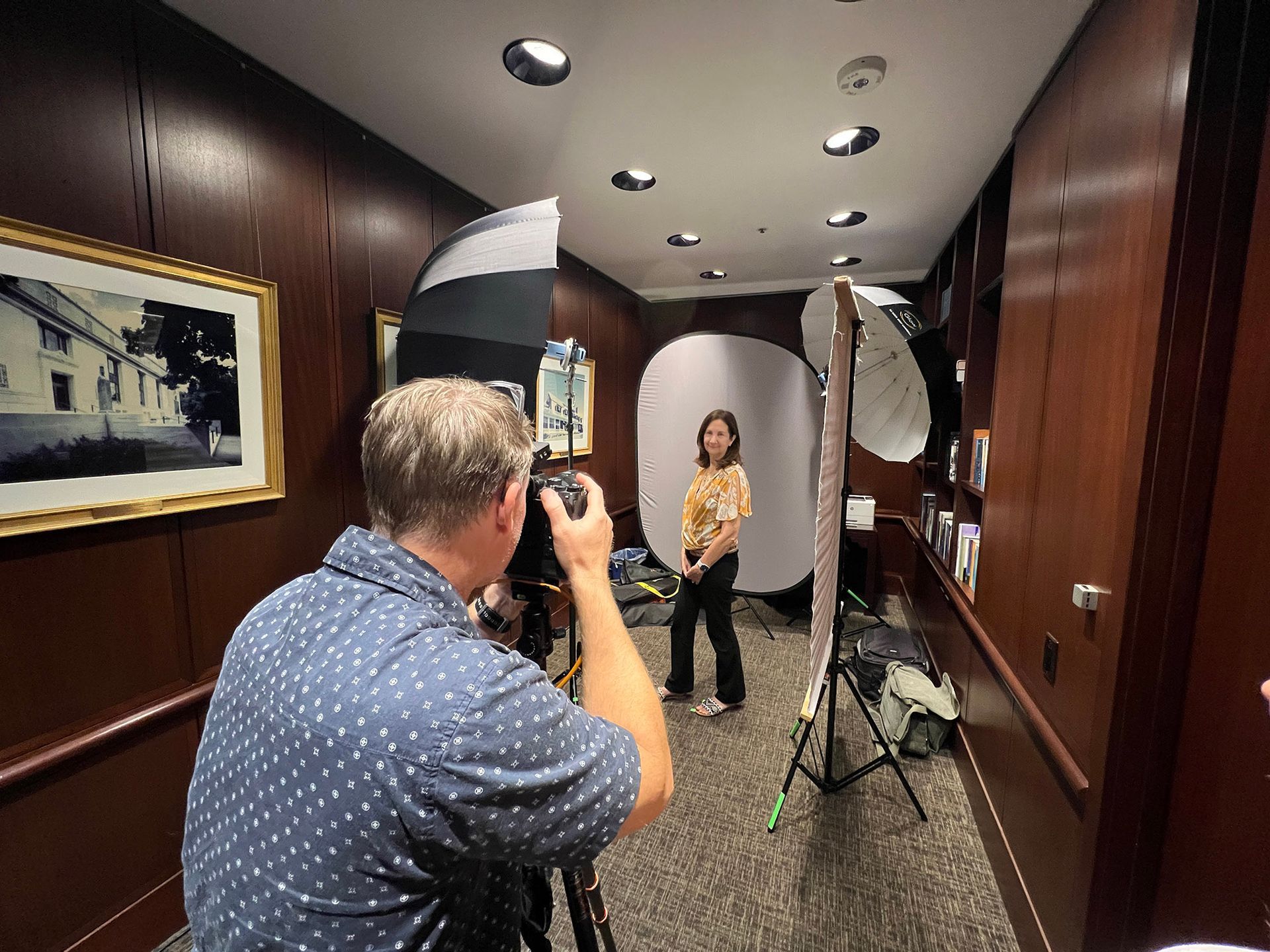 irvine team corporate headshot Photographer taking a photo of a person posing in a hallway with studio lighting.