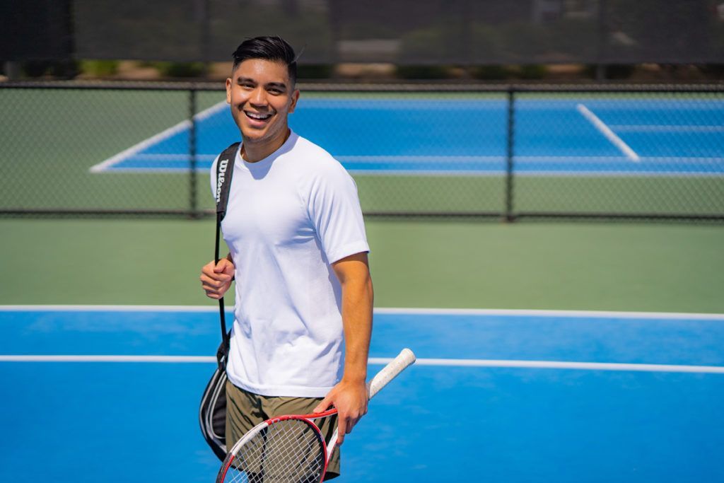 A man is holding a tennis racquet on a tennis court.