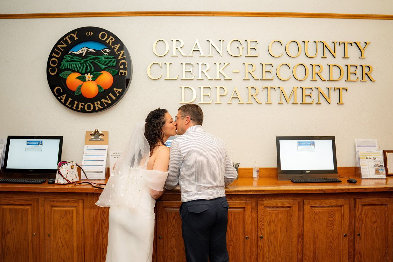 Old Orange County Clerk-Recorder Department A bride and groom kissing in front of the orange county clerk recorder department as they check in for their civil ceremony