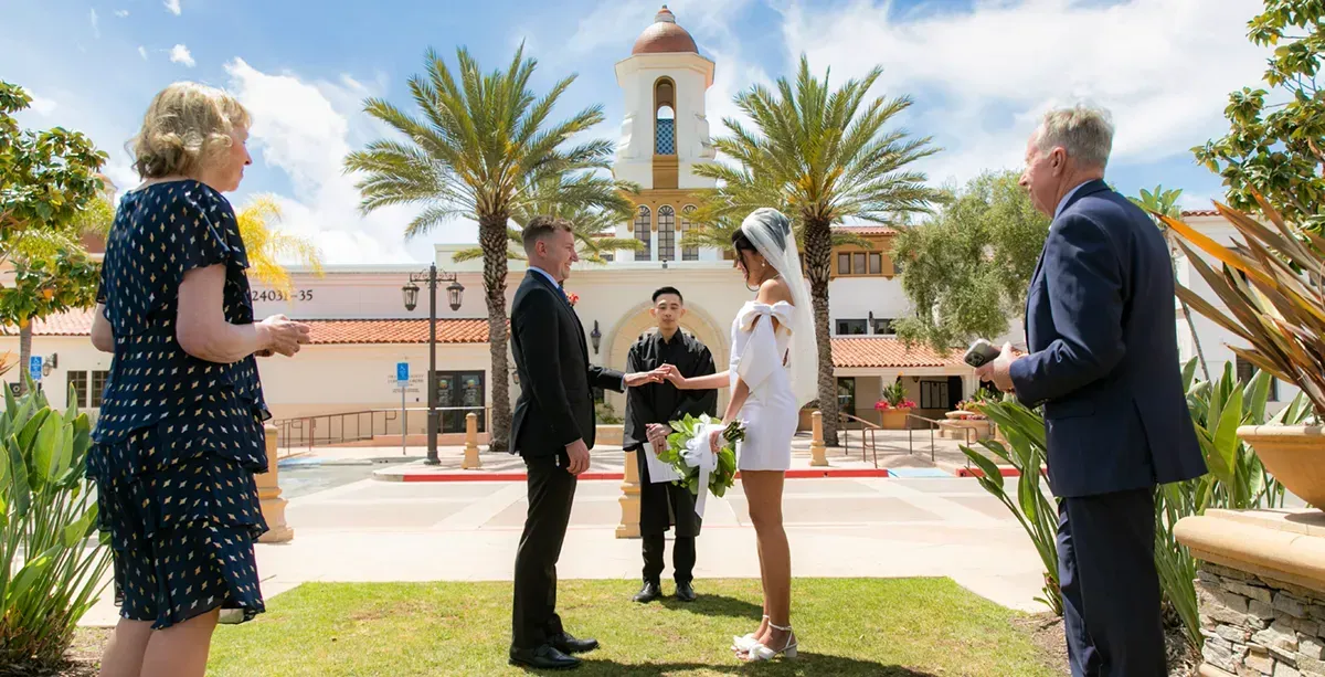 Laguna-Hills–Civic-Center A bride and groom are getting married in front of a church.