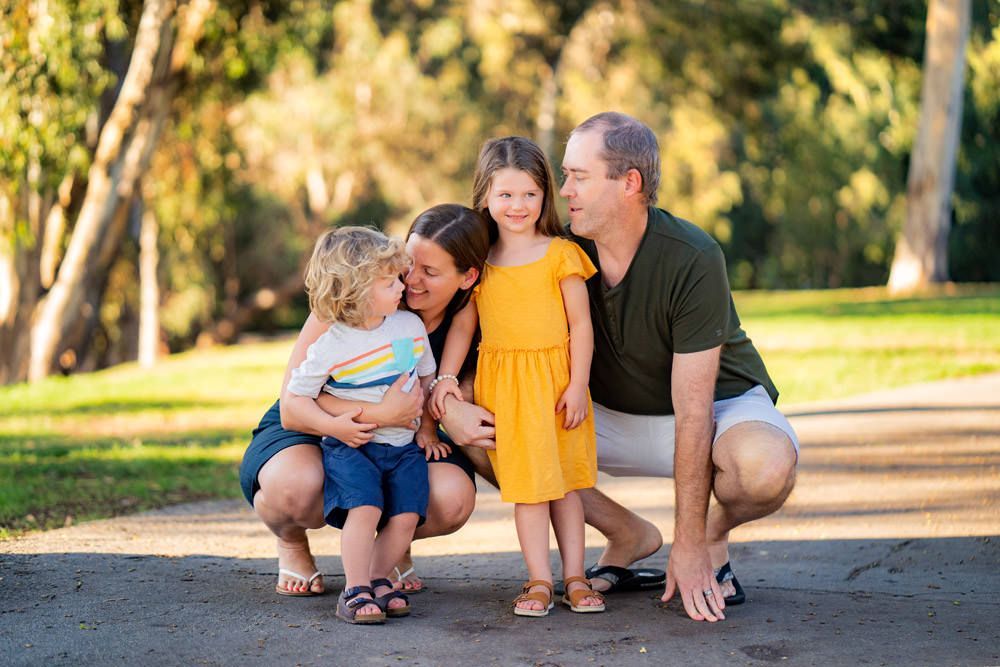 A family is posing for a picture in a park.