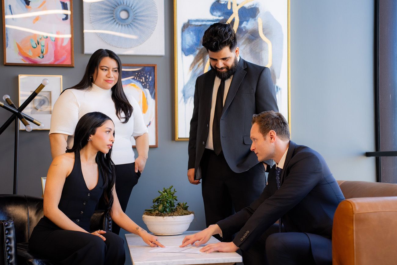 choosing a photographer for law firm Four attorneys collaborate around a coffee table in a modern office, reviewing documents together in Irvine.