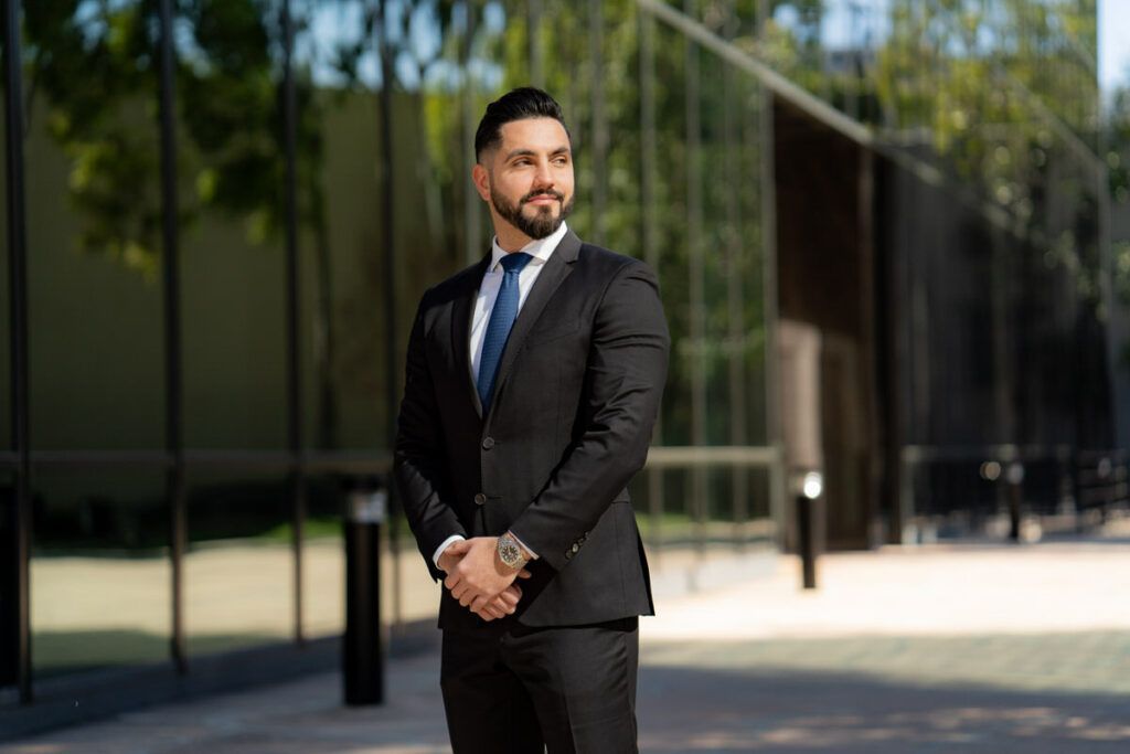 A man in a suit and tie is standing in front of a building.