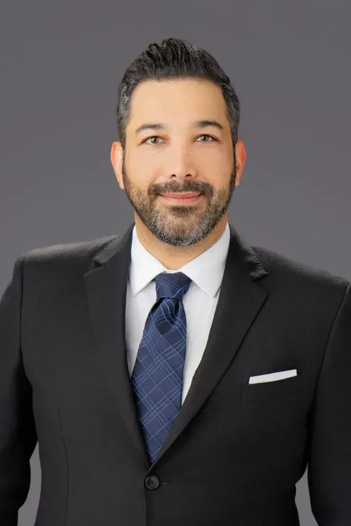 A man with a beard is wearing a suit and tie.