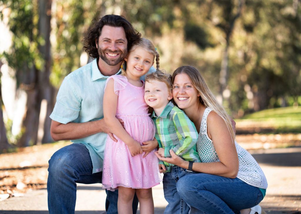 A family is posing for a picture in Central Park in Huntington Beach, CA
