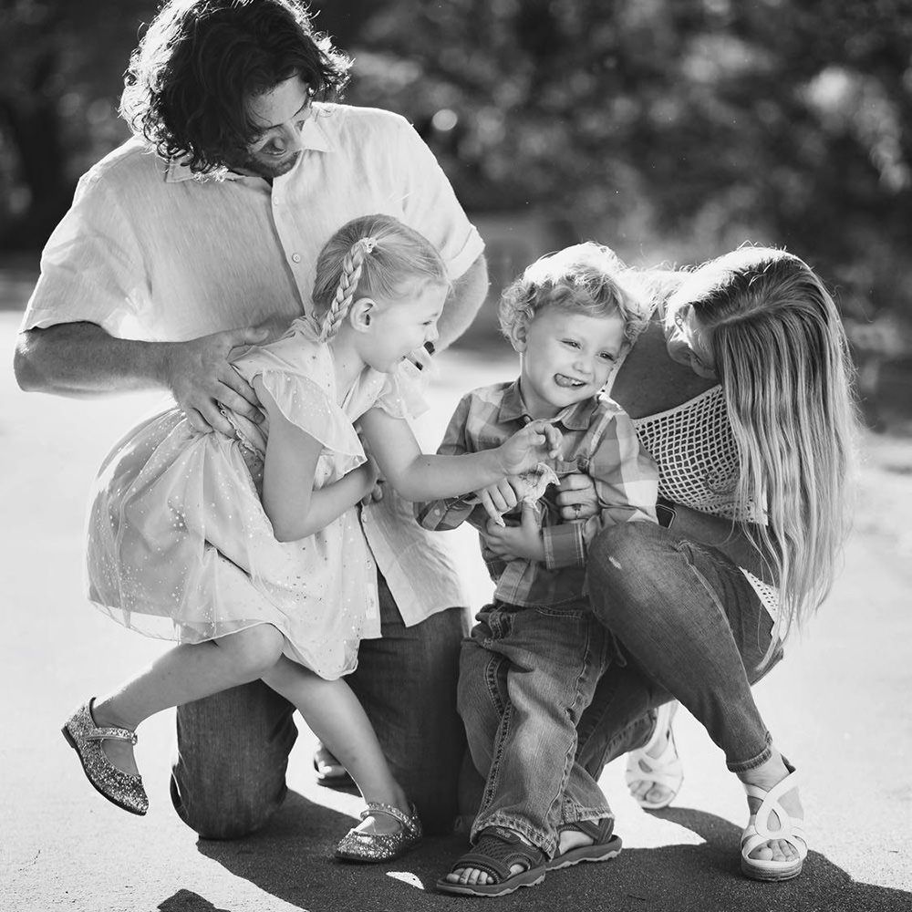 Family Portrait Session A black and white photo of a family playing together