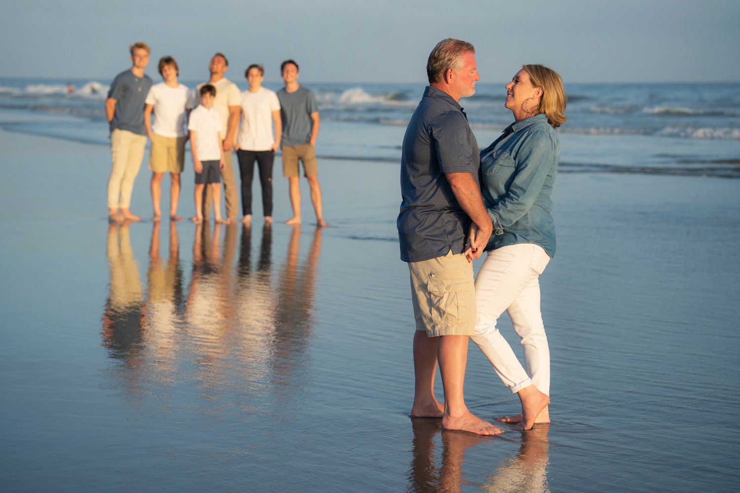Newport Beach Family Photographer A family is posing for a picture on the beach in Newport, California
